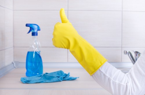 Staff following safe cleaning procedures with protective equipment